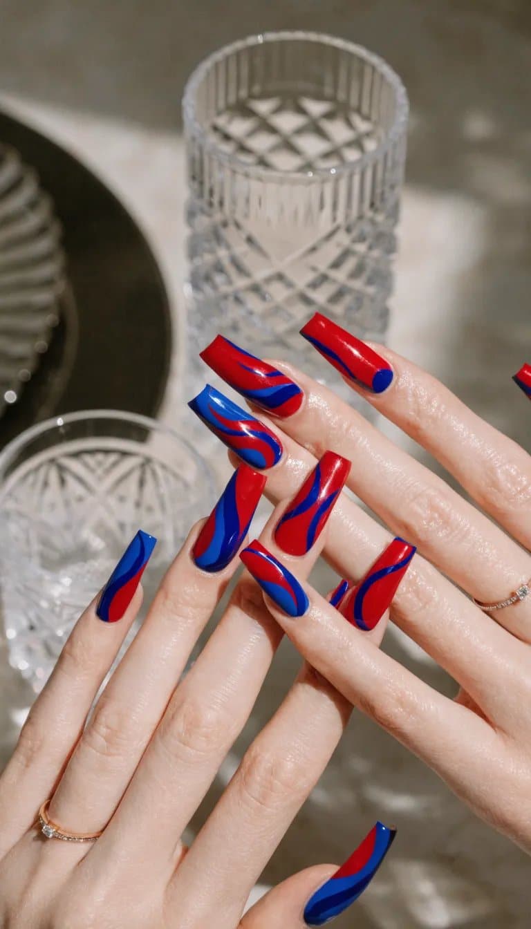 Nails with bold red and blue color blocks in a stylish design.