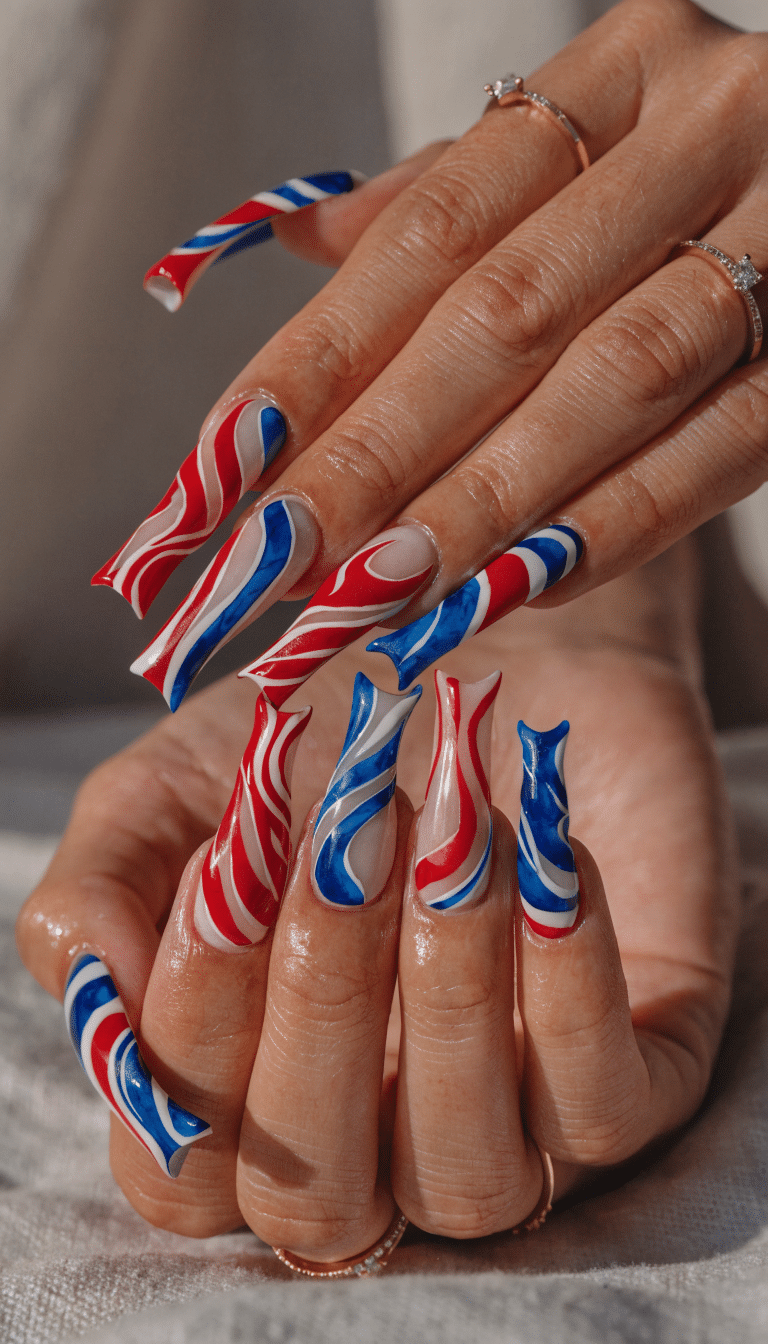 A set of creatively shaped nails painted in red, white, and blue swirls for the 4th of July
