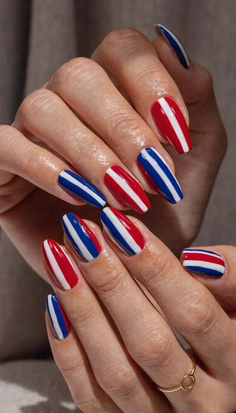 20 Stunning Red, White, and Blue Nail Art Designs for Patriotic Celebrations 3 A close-up of hands with nails featuring a red, white, and blue stripes design.
