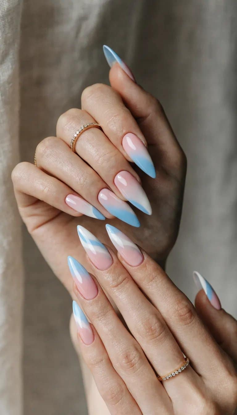 12 Simple Nail Designs You Can Do at Home 5 A close-up image of hands with pastel ombre nails featuring pink and blue gradient shades.