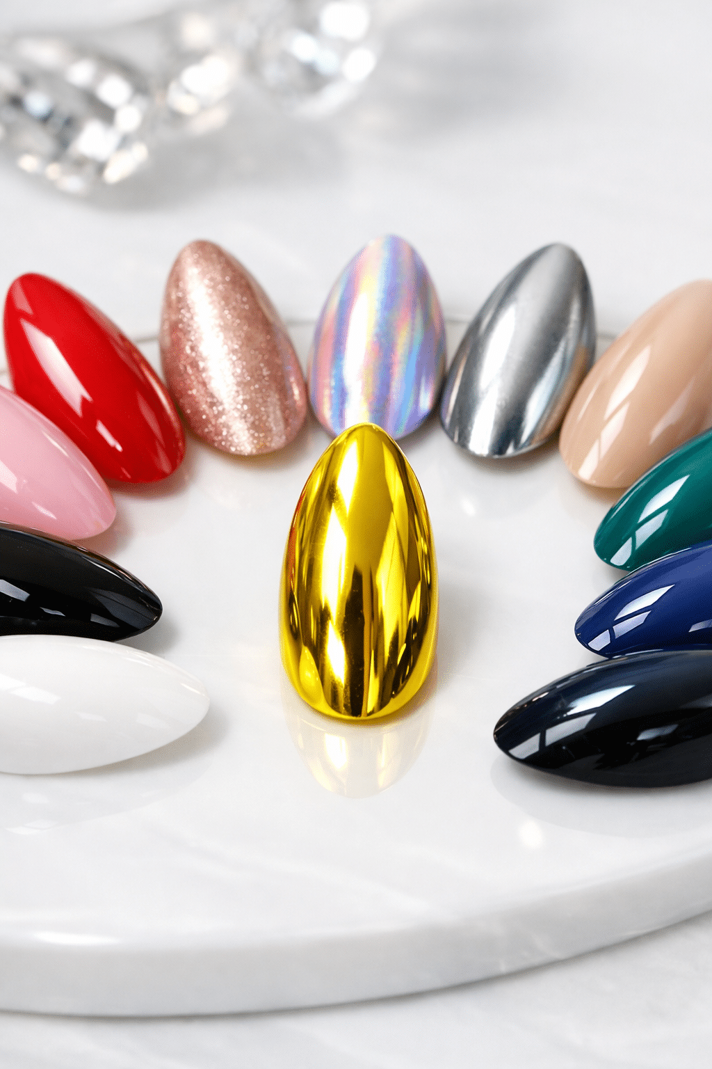 Various nails displayed in different colors and styles with a focus on a shiny yellow chrome almond nail.