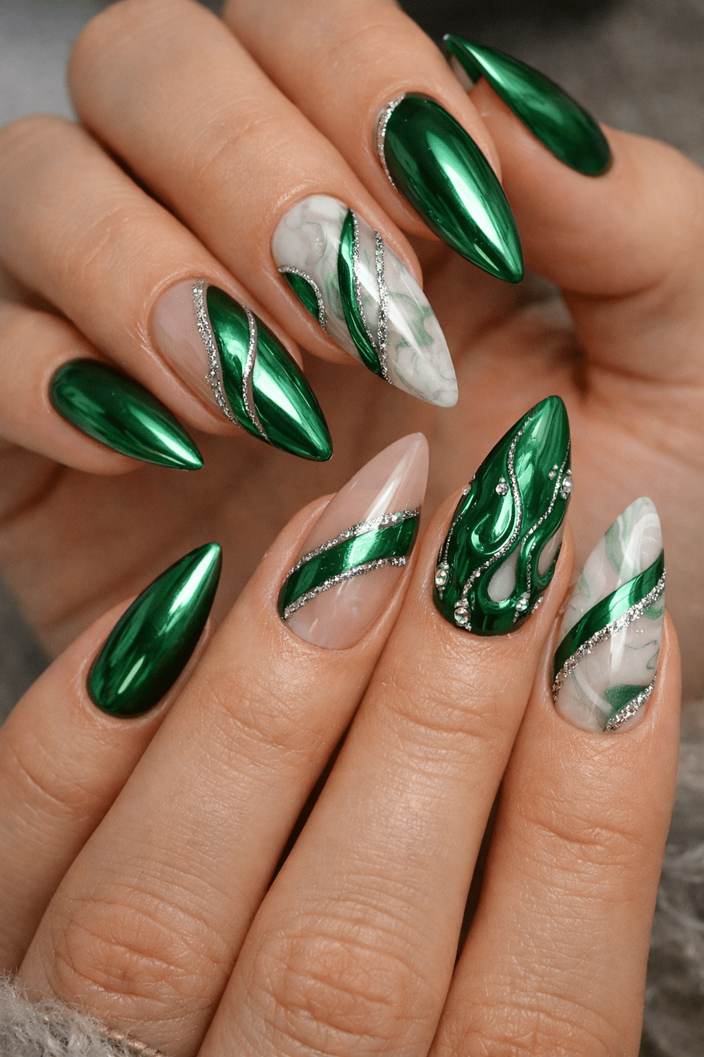 Stylish green chrome almond nails with marble and silver accents.